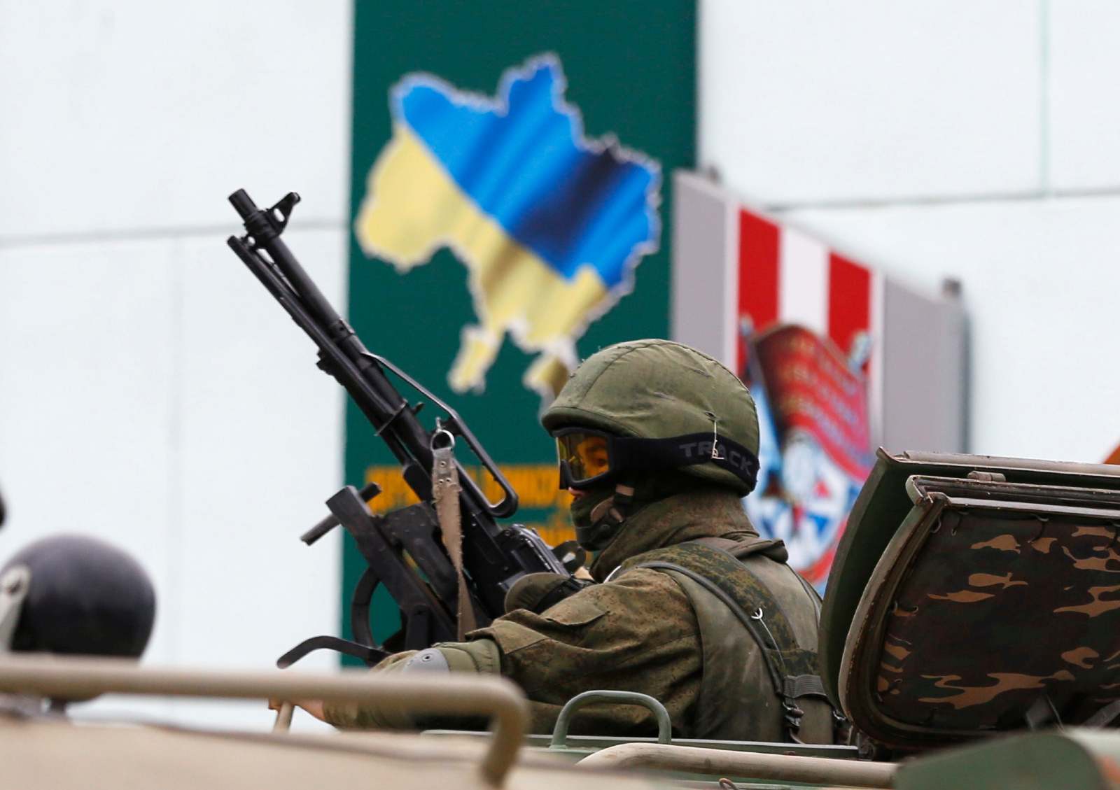 An armed serviceman looks out from a Russian army vehicle outside a Ukrainian border guard post in the Crimean town of Balaclava March 1, 2014. Ukraine accused Russia on Saturday of sending thousands of extra troops to Crimea and placed its military in the area on high alert as the Black Sea peninsula appeared to slip beyond Kiev's control.