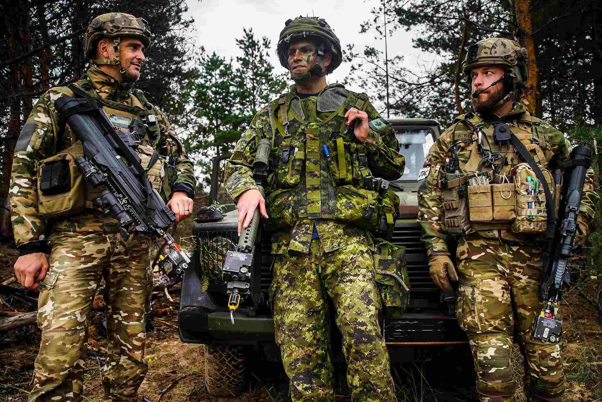 A Canadian officer from the 3rd Canadian Division speaks to members of the Slovenia J-TAC during a certification exercise. Members of the multinational battlegroup making up part of NATO's enhanced forward presence in Eastern Europe at Camp Adazi in Latvia. Credit: NATO
