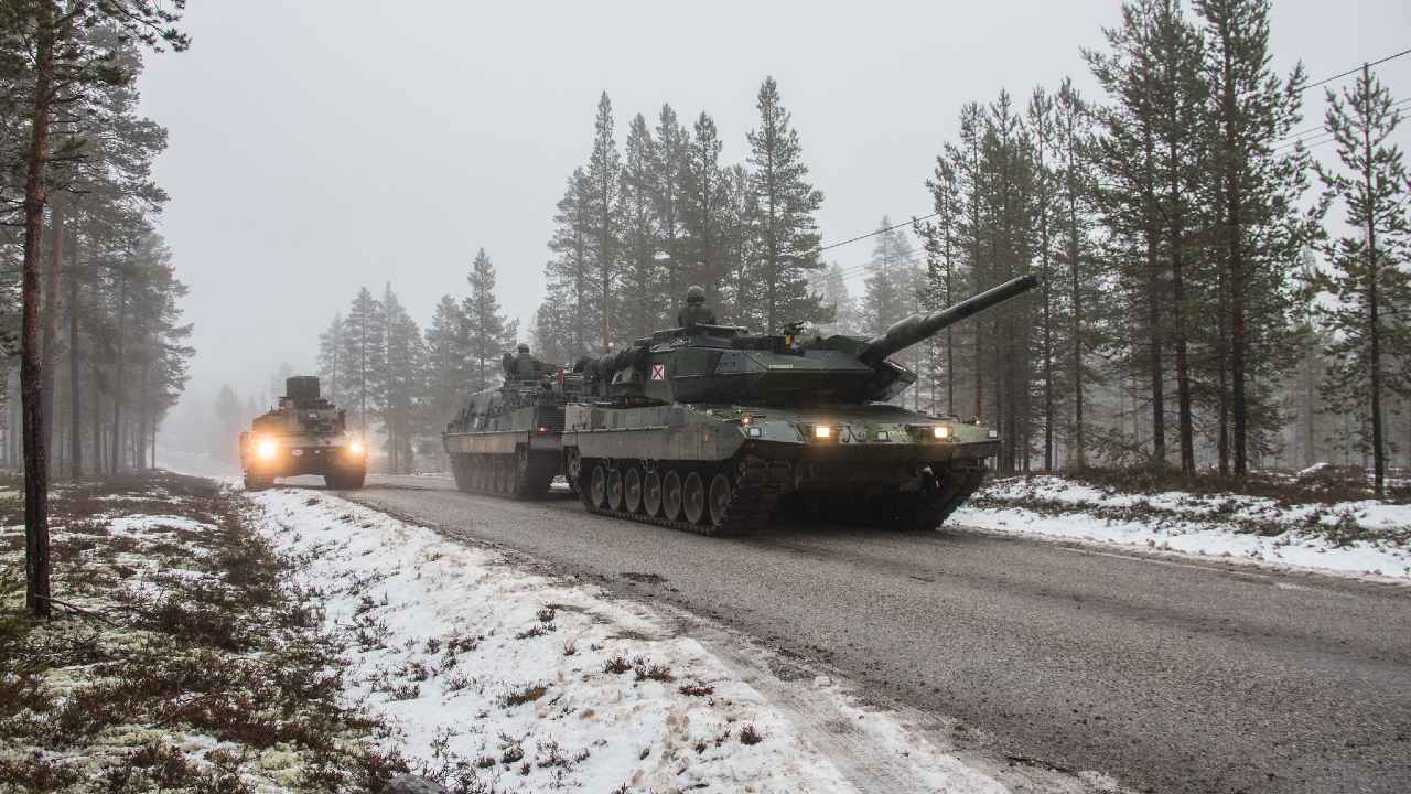 Swedish Armed Forces during Trident Juncture 2018. Swedish Leopard 122 tank taken out is towed by a tank recovery vehicle in the fog.