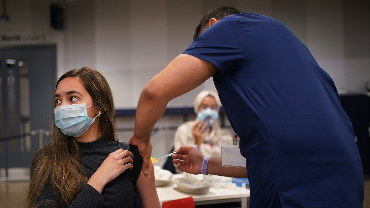 Photo: Anna Solvalag, aged 18, receives a Pfizer BioNTech COVID-19 vaccine at an NHS Vaccination Clinic at Tottenham Hotspur's stadium in north London. Sunday June 20, 2021. Credit: PA via Reuters