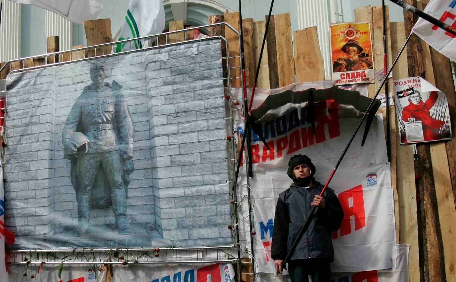 Photo: A protester holds a flag during a picket of Kremlin-loyal youth organizations in front of the Estonian embassy in Moscow on May 3, 2007. The poster on the left shows the statue of a Red Army soldier, whose relocation in Tallinn has sparked recent tensions between Russia and its ex-Soviet neighbor. Credit: REUTERS/Denis Sinyakov