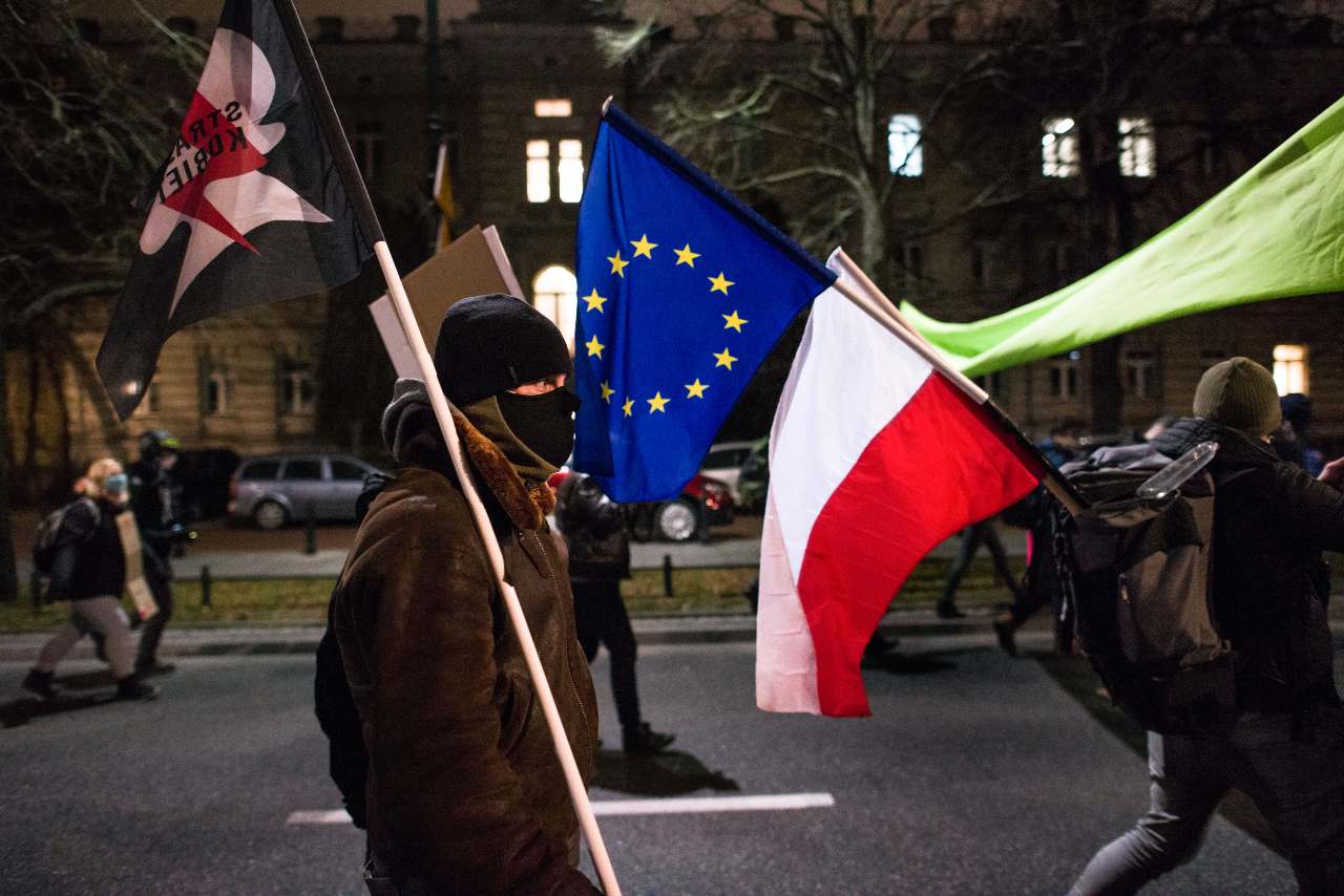 Photo: A protester walks with the Polish and the EU flag tied together during the demonstration. Under the slogan "A Walk for Future'' (Spacer dla Przyszlosci) hundreds of students gathered at the Chancellery demanding the resignation of Prime Minister, Przemyslaw Czarnek from the ruling Law and Justice (PiS) party as the minister of education and science, whom they described as "a homophobic minister proclaiming controversial views." The Women's Strike (Strajk Kobiet) and the Youth Strike for Climate (MSK) also joined the educational strike. Credit: Attila Husejnow / SOPA Images/Sipa USA