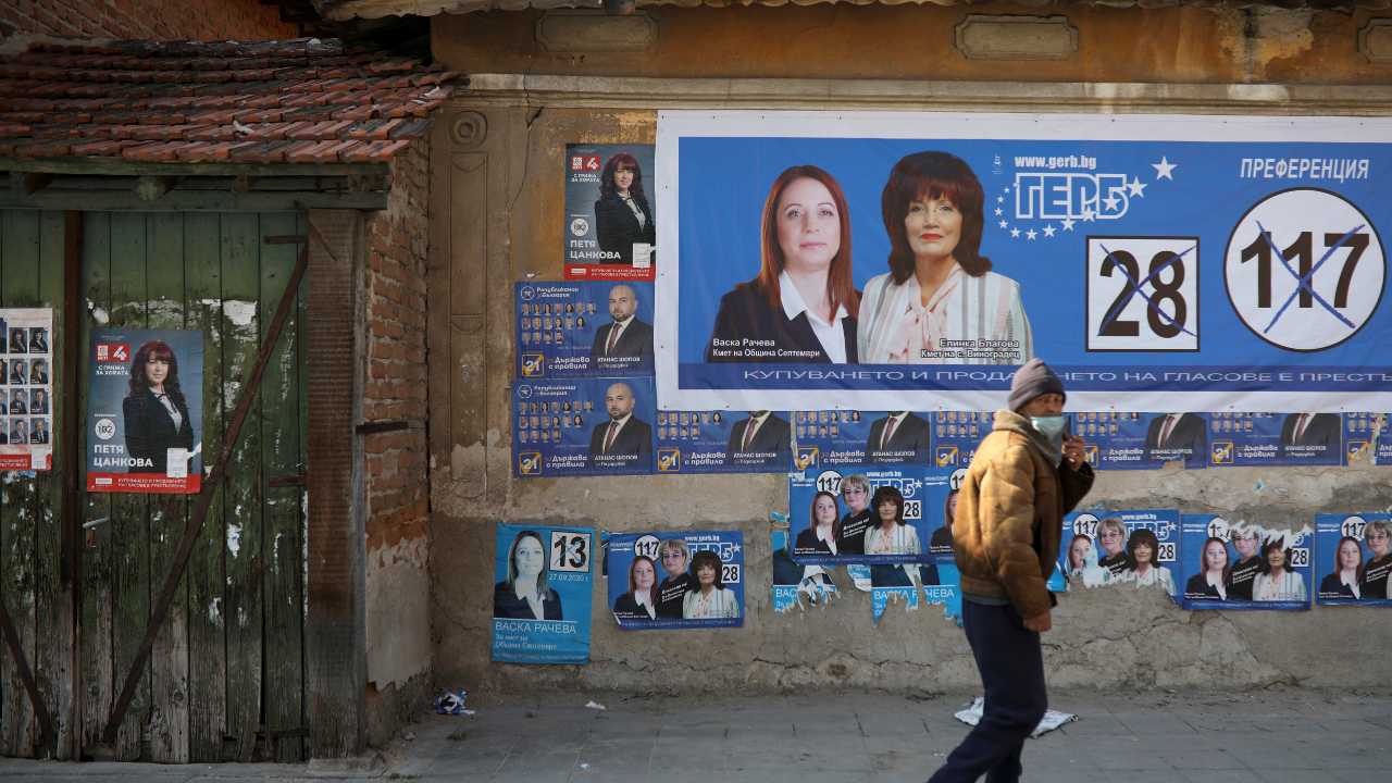 Photo: A man walks past a wall with election posters of the ruling centre-right GERB party and the opposition Bulgarian Socialist Party, in the village of Vinogradets, Bulgaria, March 28, 2021. Picture taken March 28, 2021. Credit: REUTERS/Stoyan Nenov