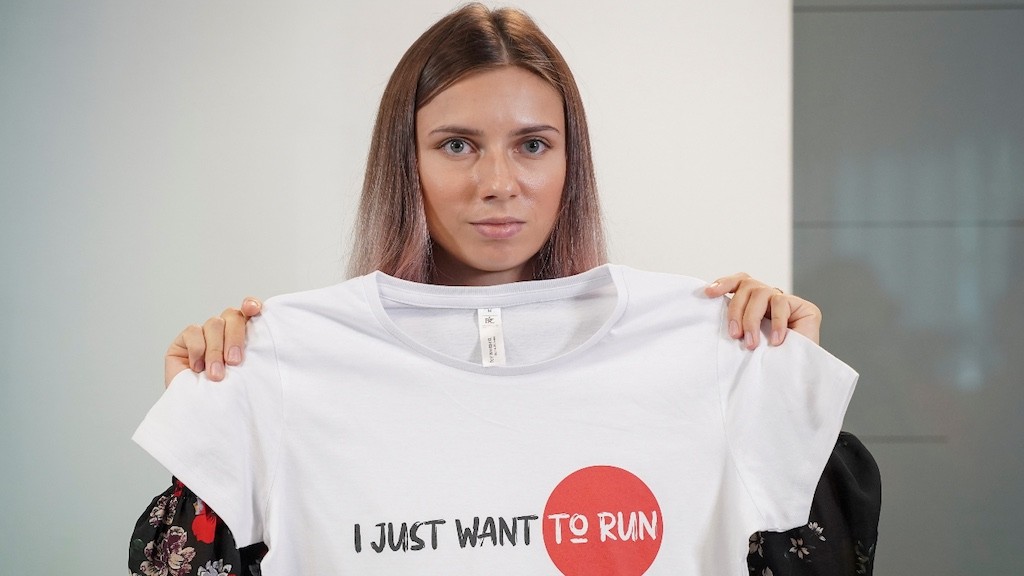 Photo: Belarusian sprinter Krystsina Tsimanouskaya, who left the Olympic Games in Tokyo and seeks asylum in Poland, holds a t-shirt at a news conference in Warsaw, Poland August 5, 2021. Credit: REUTERS/Darek Golik.