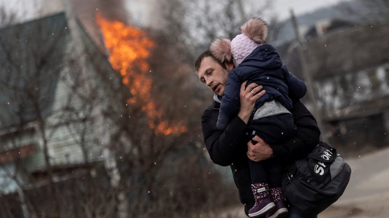Photo: A man and a child escape from the town of Irpin, after heavy shelling on the only escape route used by locals, while Russian troops advance towards the capital of Kyiv, in Irpin, near Kyiv, Ukraine March 6, 2022. Credit: REUTERS/Carlos Barria.