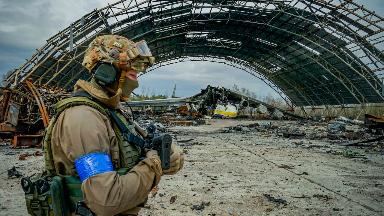 Photo: An Ukrainian soldier passes near a hangar in the Hostomel airport near Kyiv with the destroyed cargo plane Antonov An-225 Mriya. The biggest cargo plane in the world was shelled by Russian forces during its occupation of the airport. Credit: Celestino Arce/NurPhoto