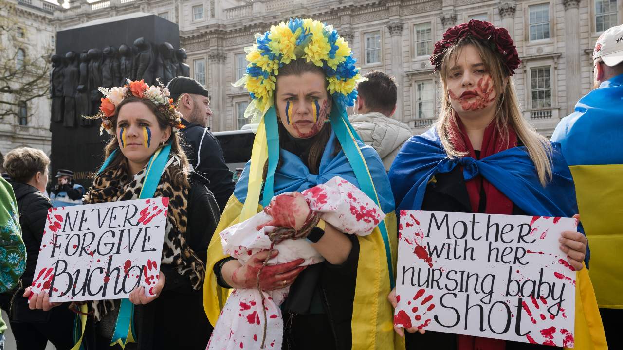 Photo: LONDON, UNITED KINGDOM - APRIL 10, 2022: Women wearing floral crowns and holding placards a doll covered in fake blood demonstrate outside Downing Street against war atrocities targeting civilians including killings and rape on the 46th day of Russian military invasion in Ukraine on April 10, 2022 in London, England. Demonstrators call on the international community to support Ukraine by supplying arms and implementing an embargo on Russian oil and gas. Credit: Wiktor Szymanowicz/NurPhoto