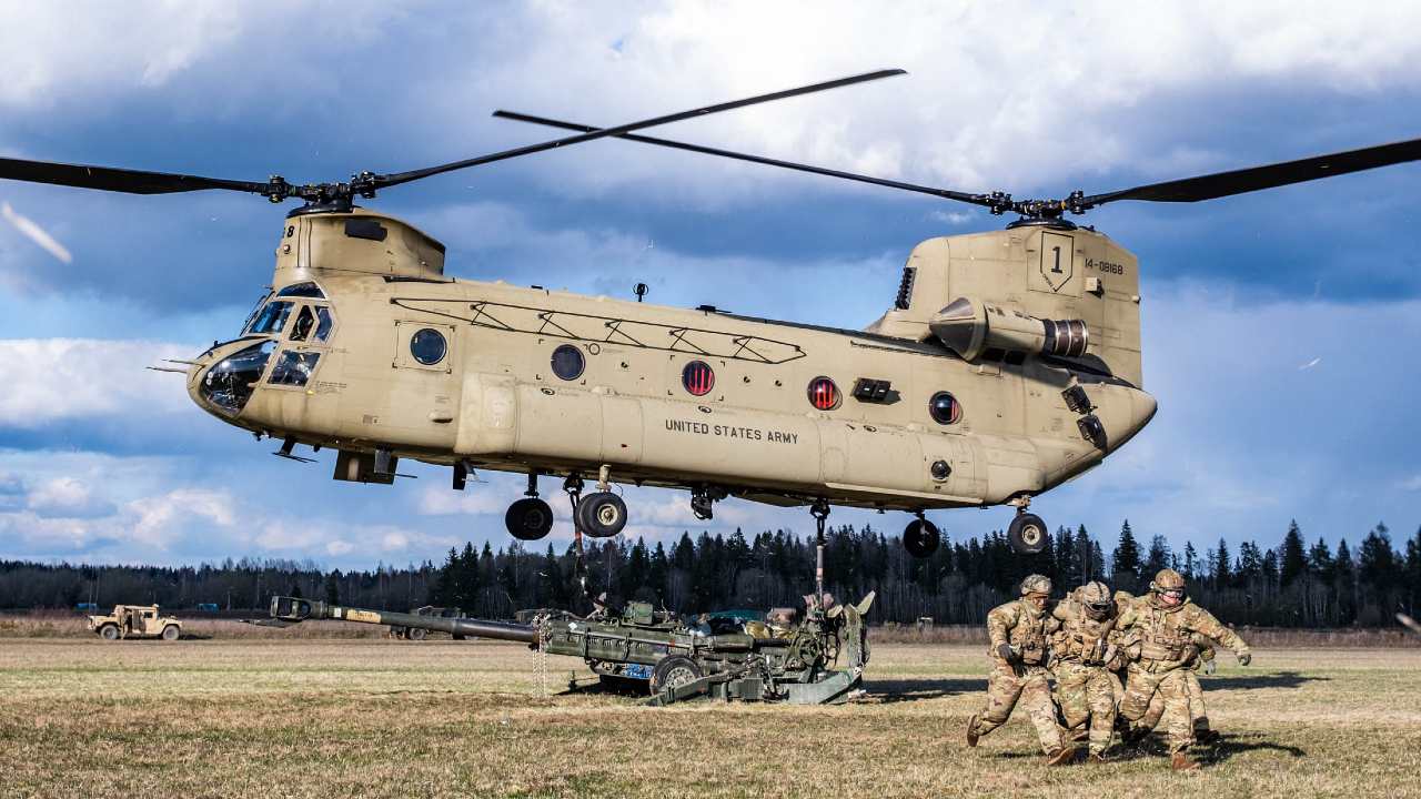 Photo: US Army paratroopers from the 82nd Airborne Division clear the area so that a Chinook helicopter can lift an M-777 Howitzer during exercise Swift Response. Credit: NATO