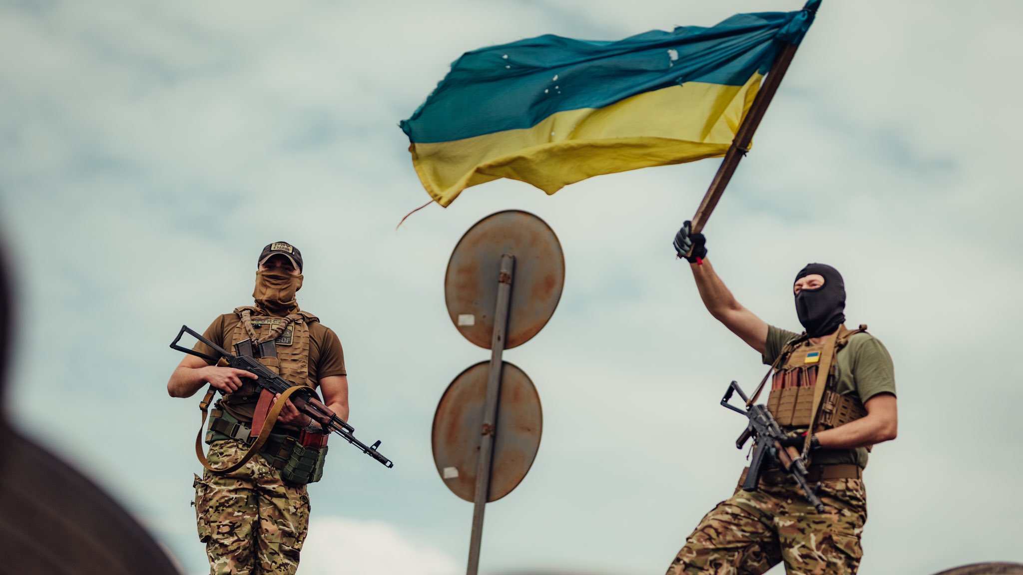 Photo: Ukrainian soldier flying a flag in celebration of Ukrainian Independence Day. Credit: Arsen Petrov via Twitter @ArsenPetrovAlex.