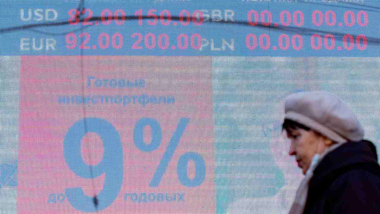 Photo: KALININGRAD, RUSSIA - FEBRUARY 24, 2022: A woman walks past a digital board displaying the current rates outside a currency exchange office. As of 10 am, the Moscow Exchange has reported the US dollar and Euro trading at 89.6 and 99.99 respectively against the Russian rouble, thus reaching their historic highs. Credit: Vitaly Nevar/TASS.