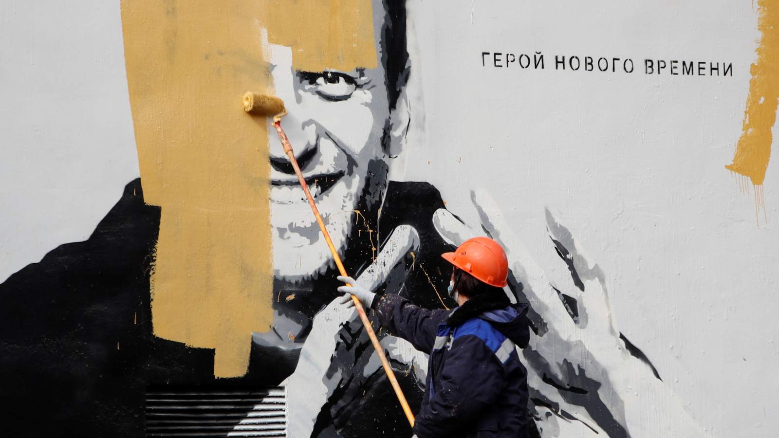 Photo: A worker paints over a graffiti depicting jailed Russian opposition politician Alexei Navalny in Saint Petersburg, Russia April 28, 2021. The graffiti reads: "The hero of the new age". Credit: REUTERS/Anton Vagano