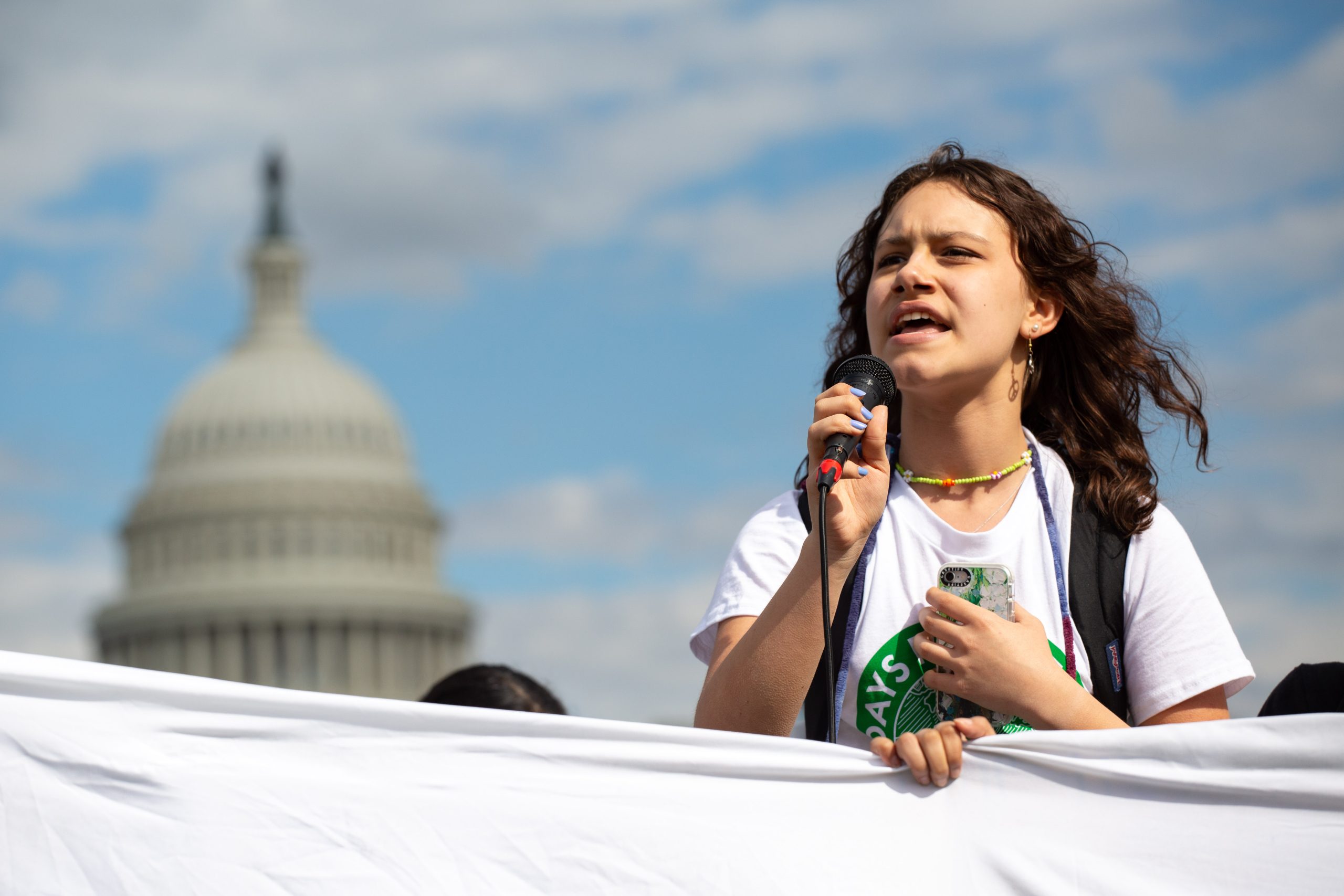 Photo: A climate activist speaks after a march from the White House to the U.S. Capitol on March 25, 2022. Credit: Bryan Olin Dozier/NurPhoto