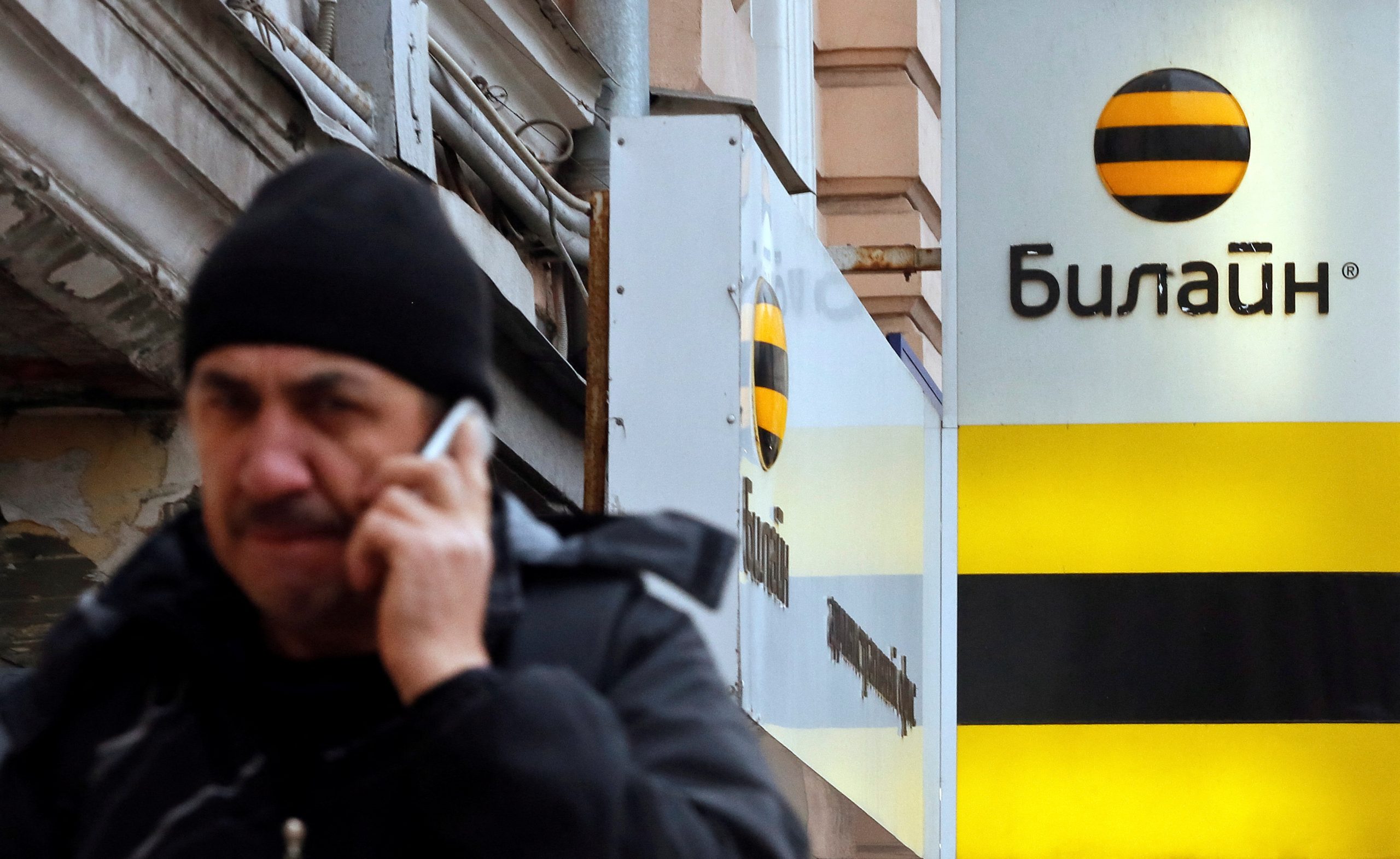 Photo: A man speaks on the phone near an office of Beeline, the brand owned by mobile phone operator Vimpelcom, in Moscow, November 12, 2014. Credit: REUTERS/Maxim Shemetov/File Photo