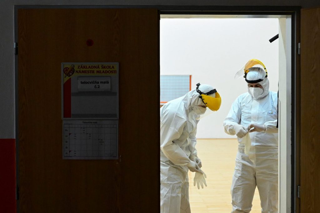 Photo: Polish healthcare workers put on their PPE during a mass nationwide testing for coronavirus disease (COVID-19) in Zilina, Slovakia, January 23, 2021. Credit: REUTERS/Radovan Stoklasa