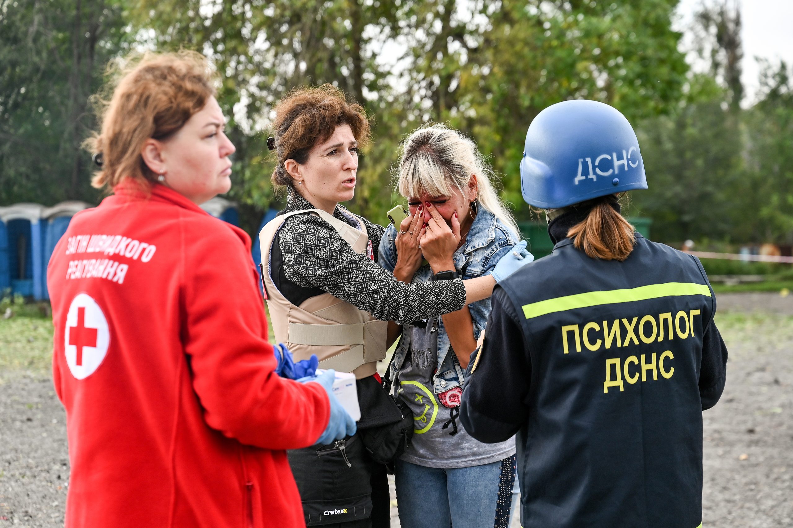 Photo: ZAPORIZHZHIA, UKRAINE - SEPTEMBER 30, 2022 - Workers of the Ukrainian Red Cross Society and a psychologist of the State Emergency Service comfort a woman at the scene of a deadly Russian missile strike on a humanitarian convoy in Zaporizhzhia, southeastern Ukraine. Credit: Dmytro Smolienko via Reuters Connect
