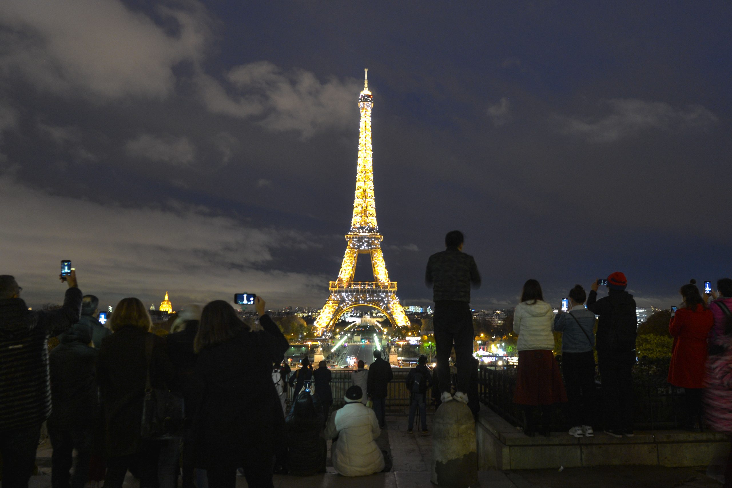 Photo: Crowds gather on Trocadero terrace to watch the Eiffel Tower sparkling illumination effects. On Tuesday, November 13, 2018, in Paris, France. Credit: Artur Widak/NurPhoto