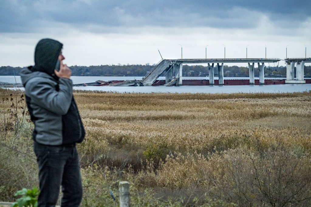 Photo: A man looks at the left side of the Dnipro River occupied by Russian army and separated by the destroyed Antonivskyi Bridge. Credit: Celestino Arce/NurPhoto