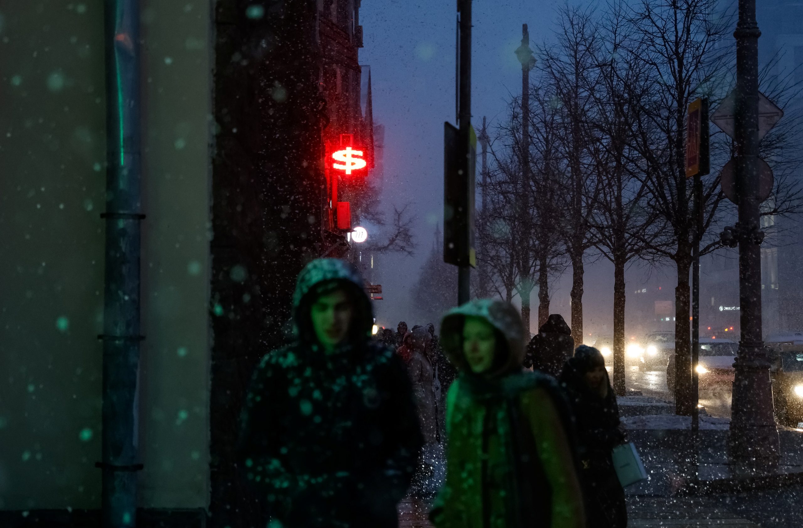 Photo: People walk in the street during heavy snowfall as a sign in the shape of the dollar symbol is seen on a currency exchange office in the background, in Moscow, Russia, April 6, 2022. Credit: REUTERS/Maxim Shemetov