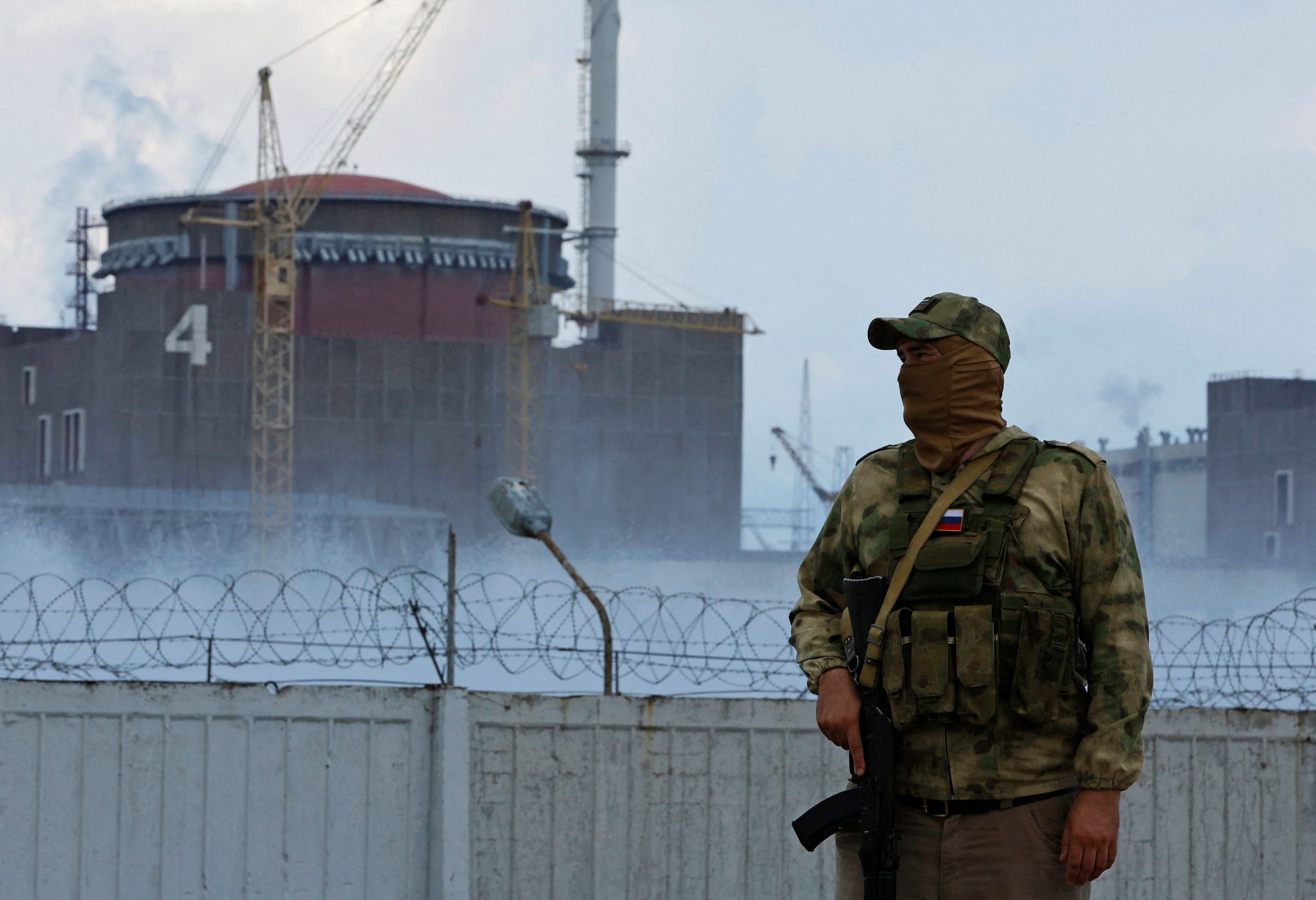 Photo: A serviceman with a Russian flag on his uniform stands guard near the Zaporizhzhia Nuclear Power Plant in the course of Ukraine-Russia conflict outside the Russian-controlled city of Enerhodar in the Zaporizhzhia region, Ukraine August 4, 2022. Credit: REUTERS/Alexander Ermochenko